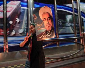 A supporter of moderate cleric Hassan Rohani celebrates his victory in Iran's presidential...