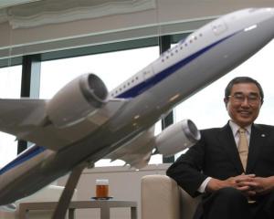 All Nippon Airways co-president Shinichiro Ito with a model of Boeing 787 Dreamliner aircraft....