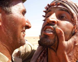 An anti-Gaddafi fighter congratules another fighter after he captured a sniper at the Bani Walid...