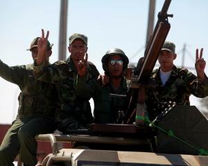 Anti-Gaddafi fighters pose for a picture while patrolling around Brega oil fields, Libya. Photo:...