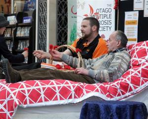 April Perkins McMillan (7) makes a donation to Otago Multiple Sclerosis field officer Don Benn ...