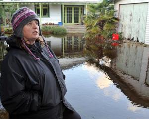 Aramoana League member Vicki Wilson stands next to one of about a dozen Aramoana properties which...