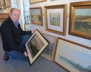 Arrowtown Gallery manager Simon Beadle admires newly released original artworks by  deceased...