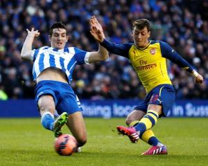 Arsenal's Mesut Ozil (R) shoots to score against Brighton and Hove Albion during their FA Cup...