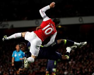 Arsenal's Robin van Persie (L) challenges Wigan Athletic's Maynor Figueroa during their Premier...