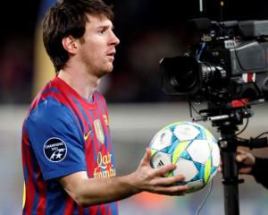Barcelona's Lionel Messi holds a ball as he leaves the pitch after scoring five goals against...