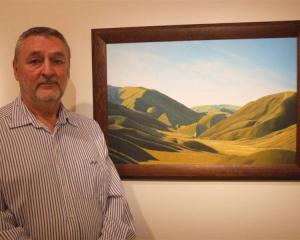 Barry Mackenzie with a painting of the Lindis Pass which is part of his exhibition at the...