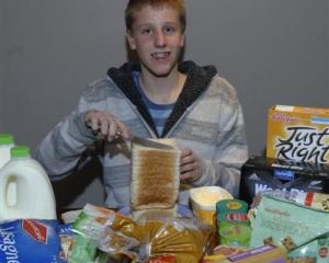 Ben Wardhaugh (14) with some of the food he and his three brothers consume in a week, in his...
