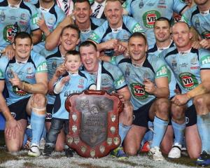 Blues players pose with the trophy after game three of the State of Origin series. (Photo by Mark...