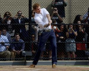 Britain's Prince Harry hits a baseball while participating in a baseball clinic in New York....