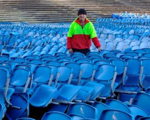 Carisbrook Rotary Project chairman Brendon Bearman stands among a stack of Carisbrook seats for...