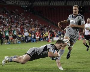 Cory Jane scores a try for the Hurricanes against the Lions watched by teammate James Broadhurst...