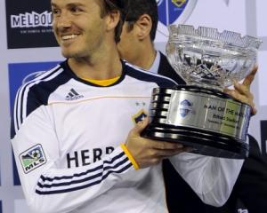 David Beckham of the LA Galaxy holds the Man of the Match award he won in his team's match...