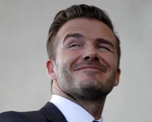David Beckham smiles at a news conference in Miami. REUTERS/Andrew Innerarity