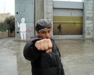 Dean Hapeta in Bethlehem next to a wall that separates Palestinian and Israeli communities.