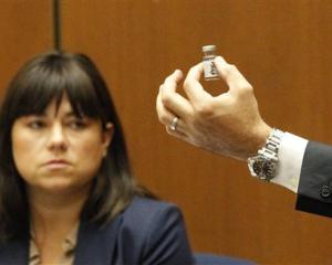 Deputy District Attorney David Walgren holds a bottle found by Los Angeles County coroner...
