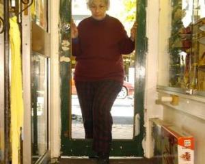Diana Struthers examines the remains of a stained-glass door she believes was smashed by vandals...