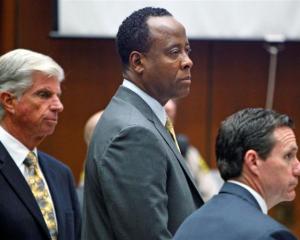 Dr Conrad Murray stands with his attorneys J. Micahel Flanagan and Edward Chernoff during his...