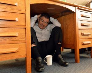Dunedin Mayor Dave Cull shelters under his desk. Photo by Stephen Jaquiery.