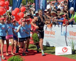 Dylan NcNeice celebrates with the crowd as he runs down the winners shute. Photo by Stephen...