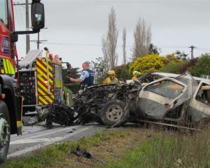 Emergency  services personnel at the scene of a crash on State Highway 1 near Maheno yesterday....