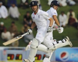 England's Alastair Cook and Jonathan Trott (L) cross for a run during the second test against...