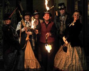 Fire-stick juggler James East welcomes steampunk ball-goers (from left) Fiona Rutland, from...