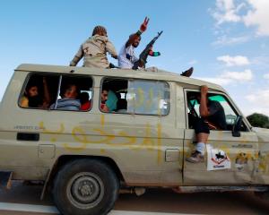 Gaddafi loyalists are captured by anti-Gaddafi fighters in a vehicle, in the centre of Sirte,...