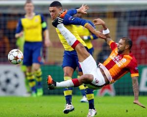 Galatasaray's Felipe Melo challenges Arsenal's Alex Oxlade-Chamberlain (top) during their...