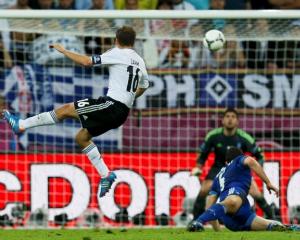 Germany's Philipp Lahm (L) scores a goal against Greece's Michalis Sifakis past Kyriakos...