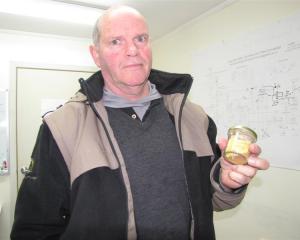 Glass Earth Gold chief executive officer Simon Henderson holds  3.4 ounces of gold recovered from...