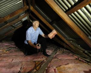 Grant Roydhouse inspects the insulation he has put into a student flat under a government subsidy...