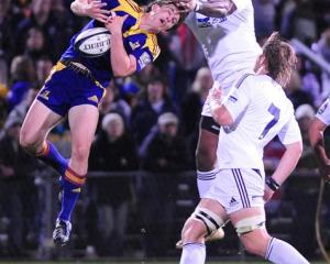 Highlanders wing Ben Smith grabs at a high ball ahead of Stormers counterpart Gcobani Bobo in...