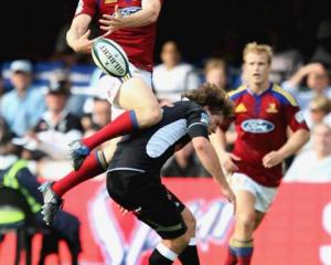 Highlanders winger Ben Smith goes high for the ball and lands on Francois Steyn, of the Sharks,...