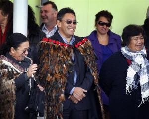 Hone Harawira, dressed in a feather cloak (korowai), is welcomed on to Rawhitiroa kura kaupapa...