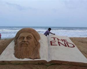 Indian sand artist Sudarshan Pattnaik gives finishing touches to a sand sculpture to mark the...