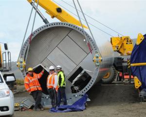Installation crew wait out the wind beside the base section of the first wind turbine column due...