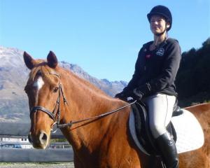 International riding instructor Suzanne Kolff sits next to the round pen used for horsemanship...