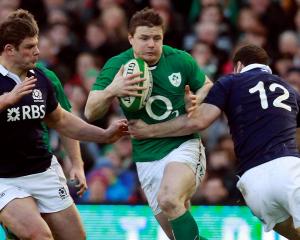 Ireland's Brian O'Driscoll (C) tries to break through the Scotland defence. REUTERS/Cathal...