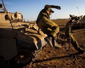 Israeli soldiers are seen in a staging area near Israel's border with the Gaza Strip, in southern...