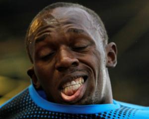 Jamaica's Usain Bolt puts on his T-shirt after winning the 100m at the IAAF World Challenge...
