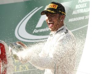 Lewis Hamilton sprays champagne on the podium after the Australian F1 Grand Prix at the Albert...