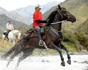 Lynne Tinkler, from the Coromandel Peninsula, bounds over a creek on the Tussock Creek light...