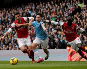 Manchester City's Samir Nasri (C) is challenged by Arsenal's Olivier Giroud (L) and Bacary Sagna....