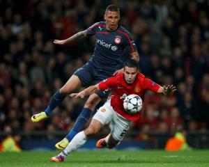 Manchester United's Robin van Persie (front) is fouled for penalty by Olympiakos' Jose Holebas....
