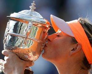 Maria Sharapova kisses the trophy after her victory over Simona Halep in the French Open final....