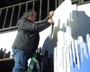 Mike Stockham installs icy decorations in Queenstown Mall yesterday outside the cinema, which...