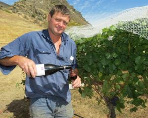 Mt Rosa co-owner Jeremy Railton samples the 2010 Mt Rosa reserve pinot noir  beside vineyards...