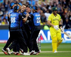 New Zealand's Trent Boult (C) is surrounded by teammates as they celebrate his dismissal of...