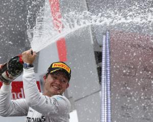 Nico Rosberg sprays champagne as he celebrates on the podium after winning the German F1 Grand...